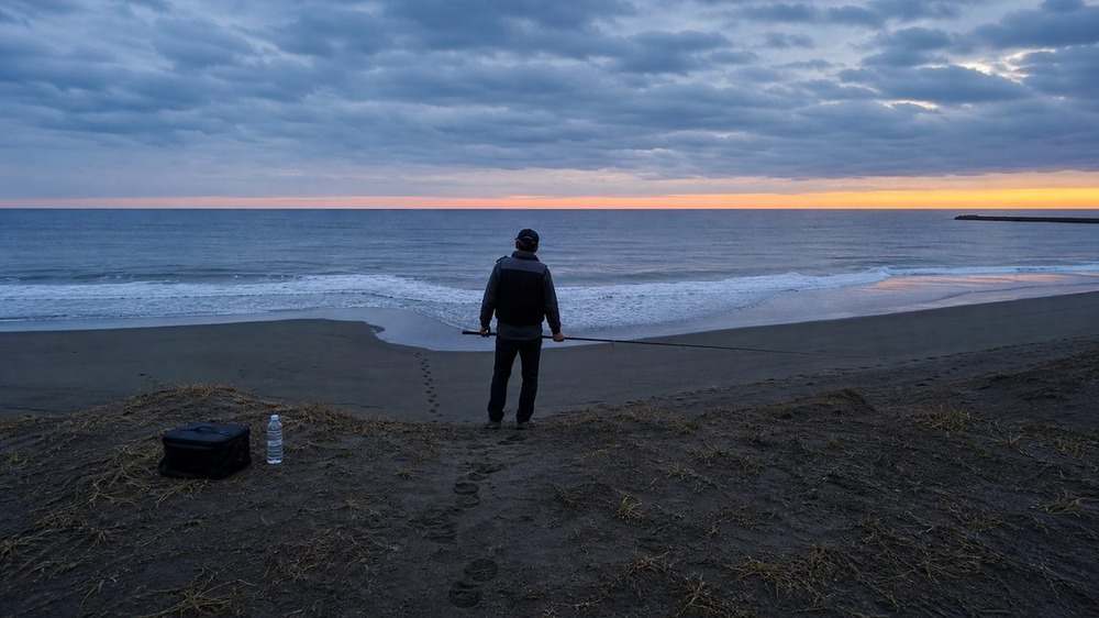 夜明け前に装備を整えて砂丘から海況を確認する中田島サーフの釣り人