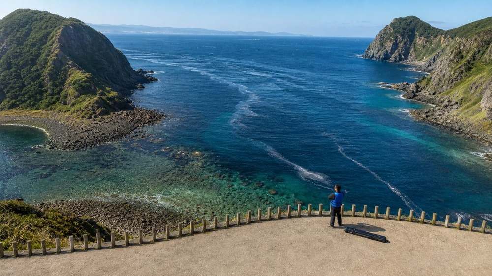 速い潮流と岩礁帯が続く津軽半島の海を安全な高台から確認する様子